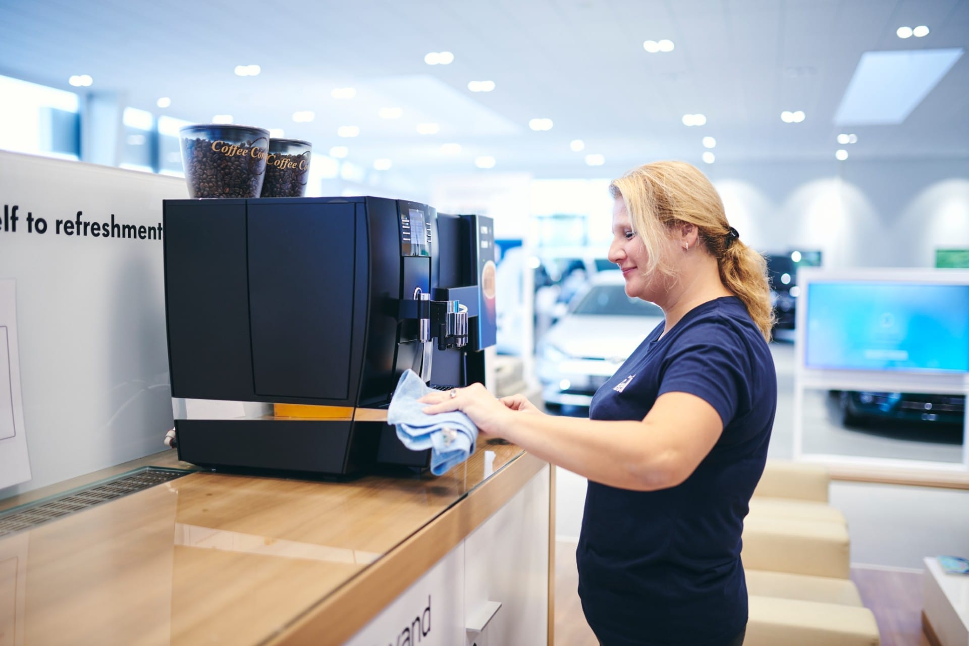 Renell-medarbejder tørrer kaffemaskine af hos erhvervskunde