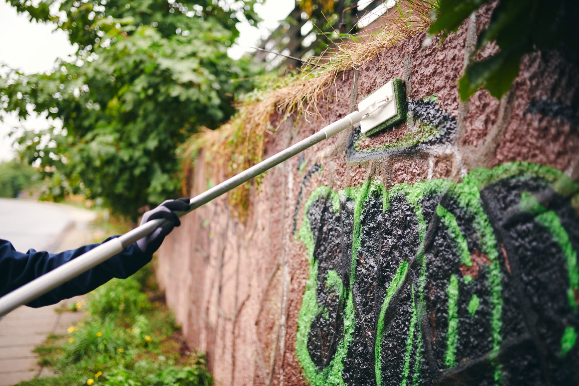 Renell-medarbejder fjerner grafitti på mur